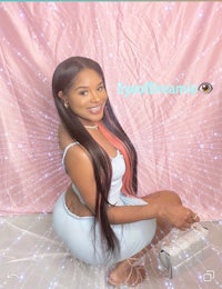 a woman in a white dress posing in front of a pink background