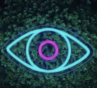 a neon eye in the middle of a forest